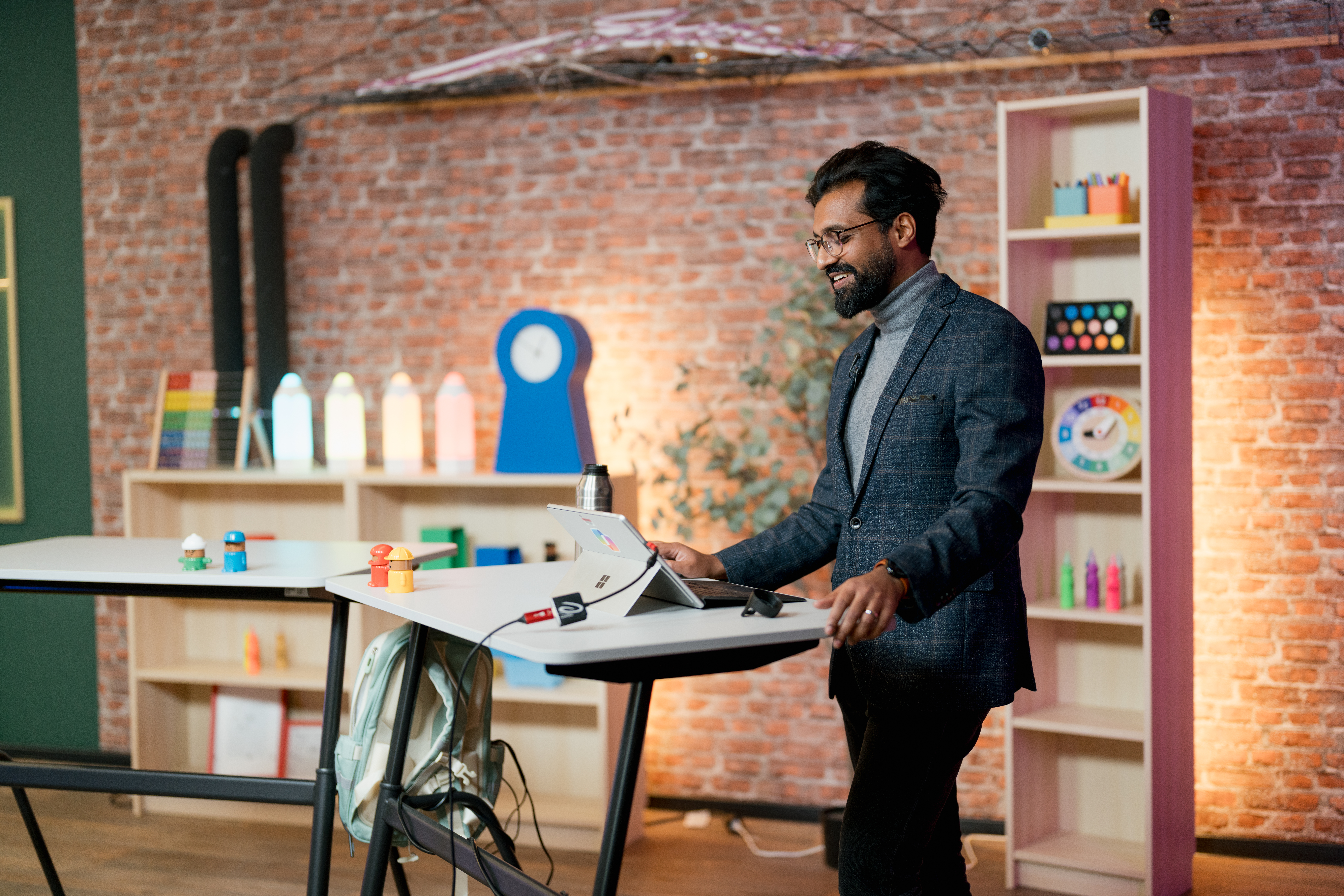 Content Fotograf, ein Herr in einem Anzug vor einem Tisch. Er bedient ein iPad.