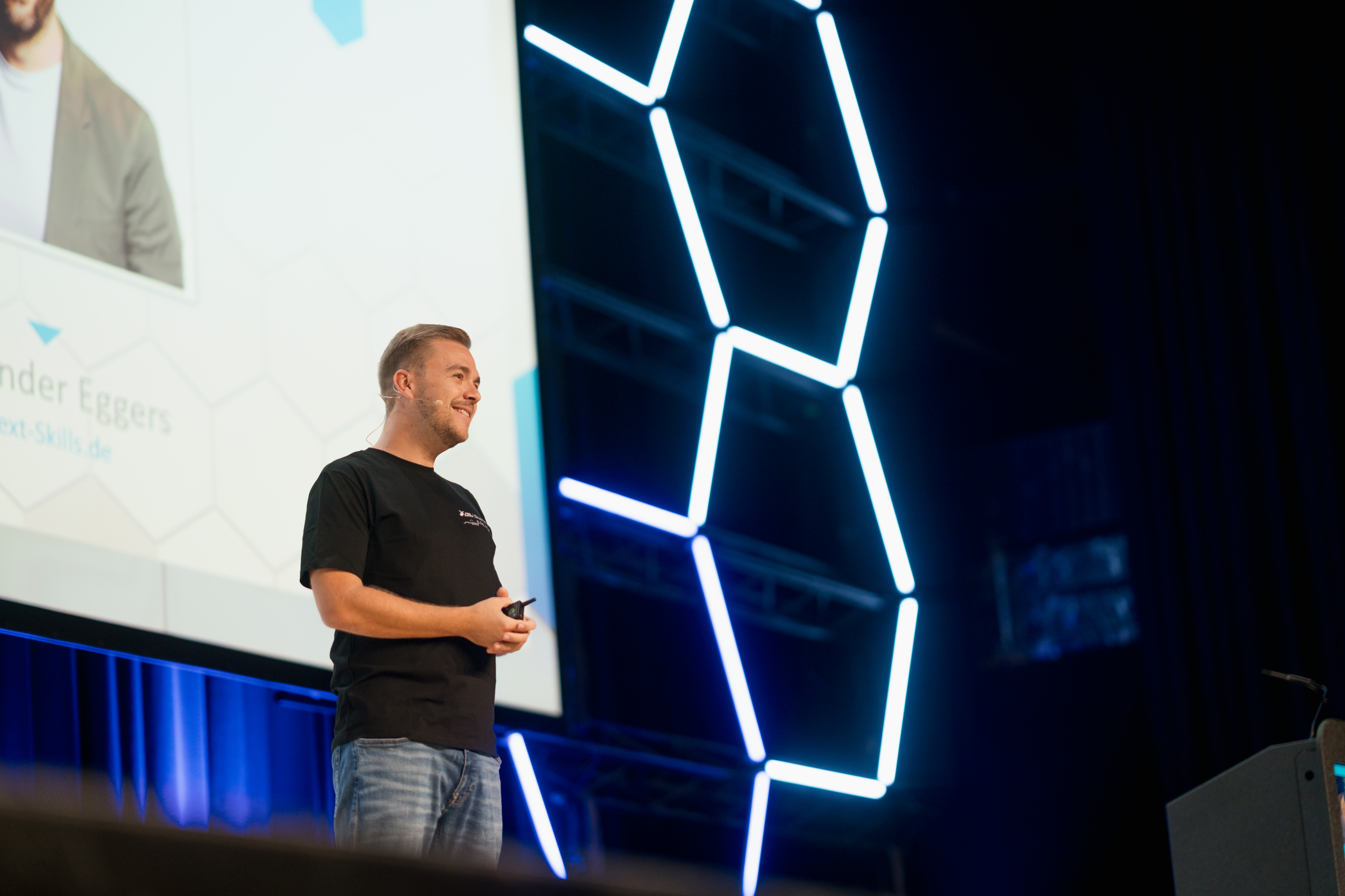 Content Fotograf, ein Herr auf einer großen Bühne, der dort einen Vortrag hält