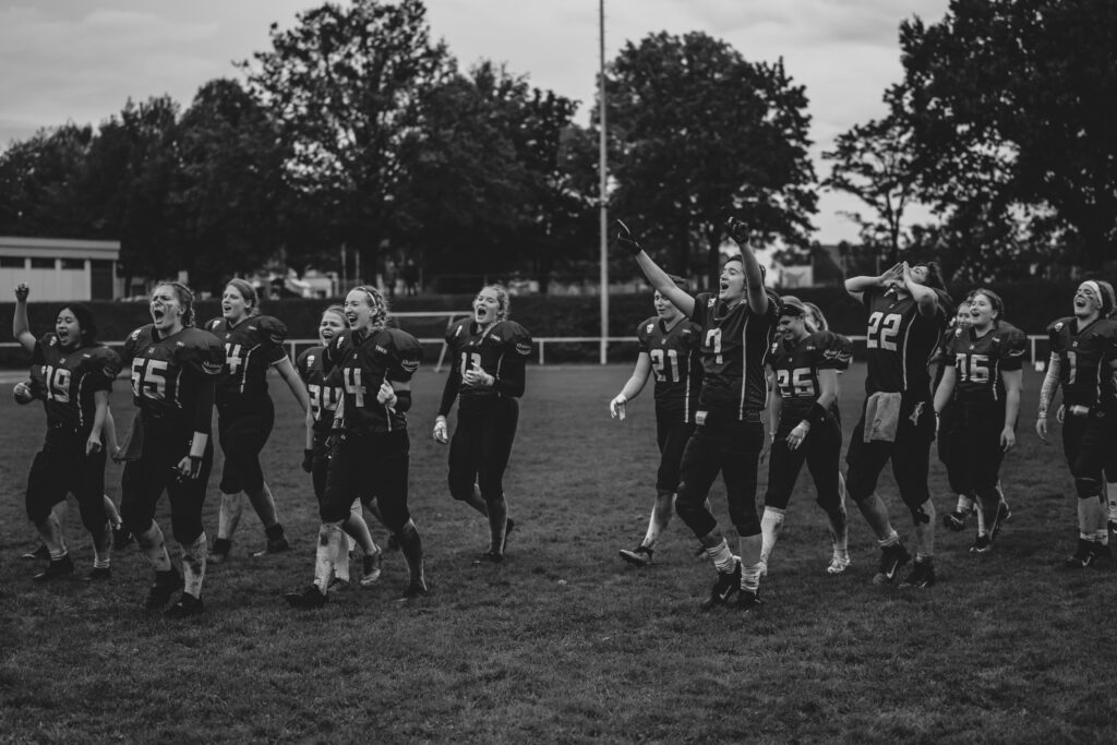 Football-Team, welches gerade auf die Zuschauer zuläuft und die einheizt