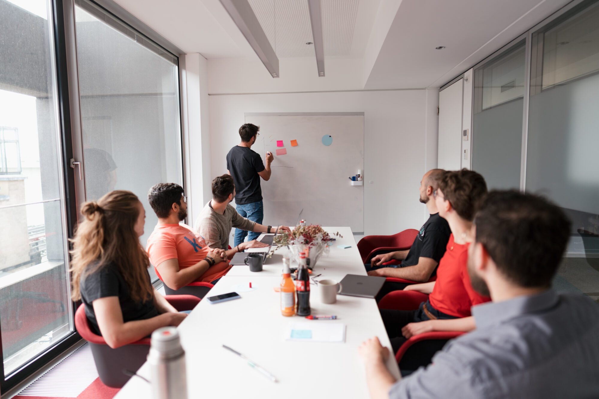 Teammitglieder sitzen um einen Tisch in einem Büro und besprechen ein Projekt - content erstellen lassen