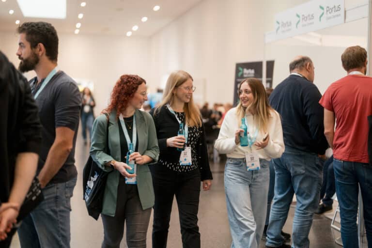 Content Planung für Social Media 4 Eine Gruppe von drei Frauen unterhält sich beim Gehen bei einem Firmenevent.