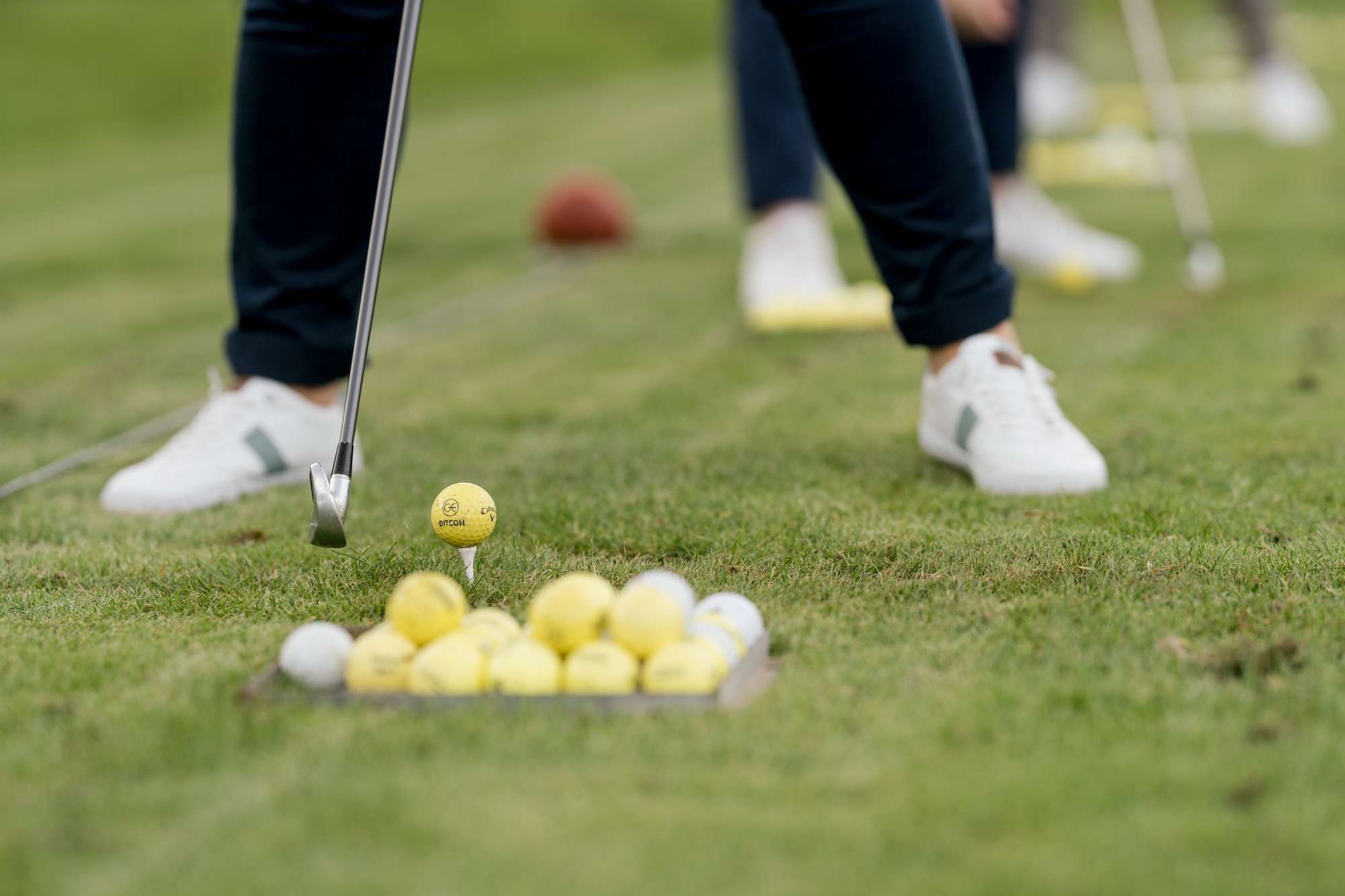 Fotografie für Social Media 4 Beine eines Spielers beim Golfen mit einem Haufen extra Bälle im Vordergrund. - Fotografie für Social Media