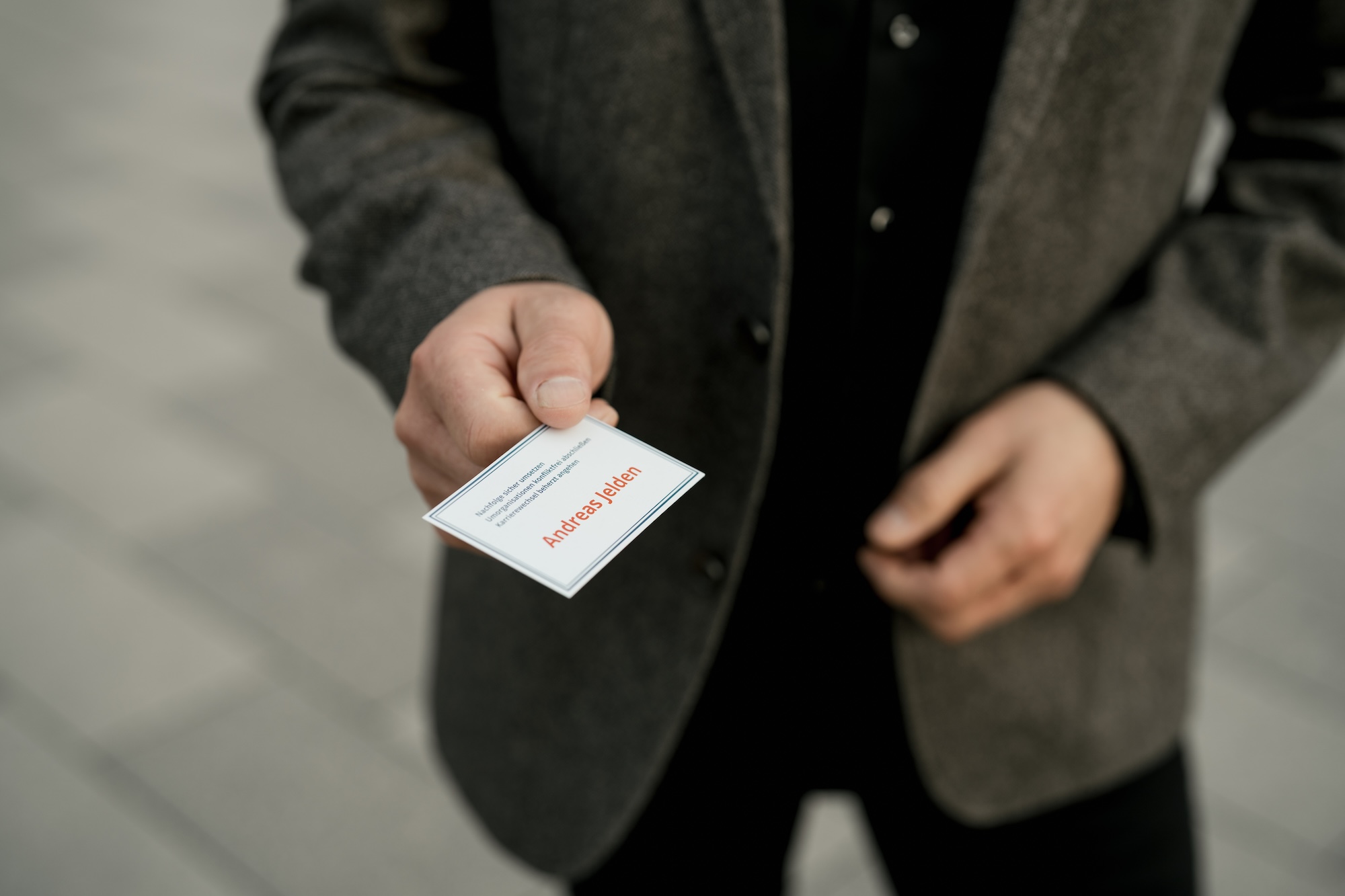 Unternehmensfotografie 4 Mann übergibt eine Visitenkarte - Unternehmensfotografie Köln.