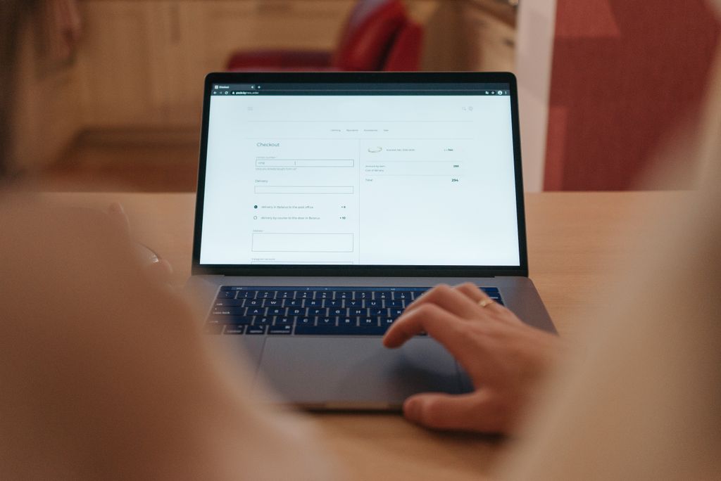Fototermin Ablauf: Was Dich bei einem Business-Shooting wirklich erwartet 2 Close-up of a person navigating online checkout on a laptop screen in a cozy indoor setting.